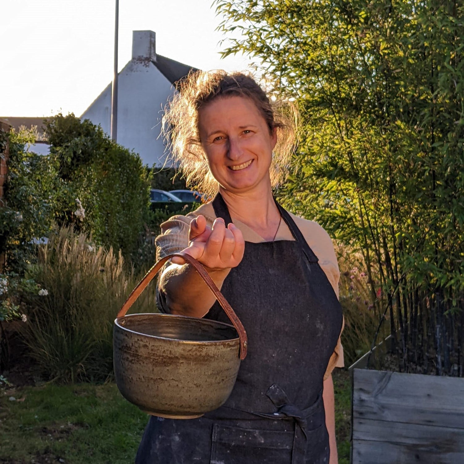 Portret van pottenbakker Ellen Verstraete met een handgemaakte keramische compostemmer